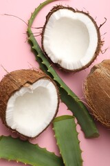 Hair treatment. Fresh coconut and aloe leaves on pink background, flat lay