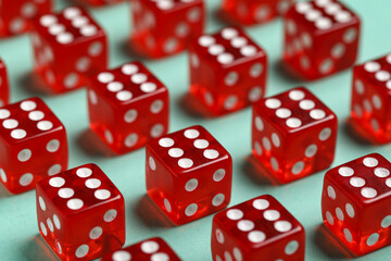 Red game dices on turquoise background, closeup