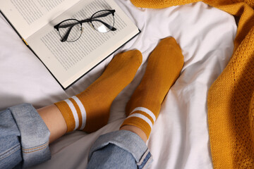 Woman wearing orange socks on bed, above view
