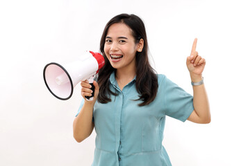 Smiling happy asian girl talking in megaphone and pointing up, announcing discount promo, showing...