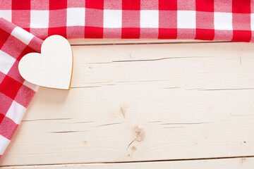 red and white checkered table cloth with a wooden heart on it