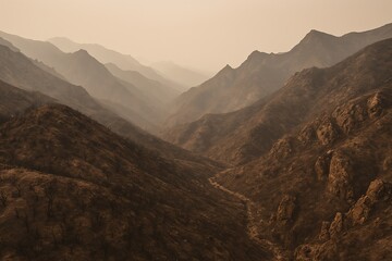 Obraz premium Stunning Mountain Landscape at Dusk with Hazy Atmosphere and Burnt Terrain