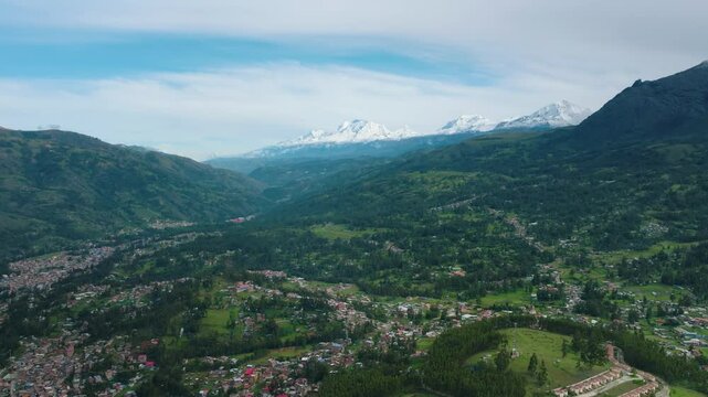 Aerial drone view of Huaraz, Peru, with a stunning horizon and the Cordillera Blanca mountains in the background.