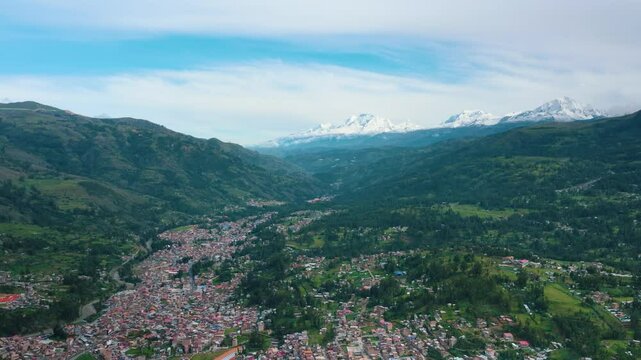 Aerial drone view of Huaraz, Peru, with a stunning horizon and the Cordillera Blanca mountains in the background.