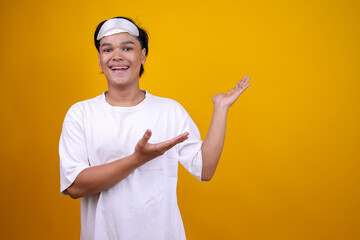 Asian Man in Pajamas and Eye Mask Presenting With Hands Aside To Copy Space