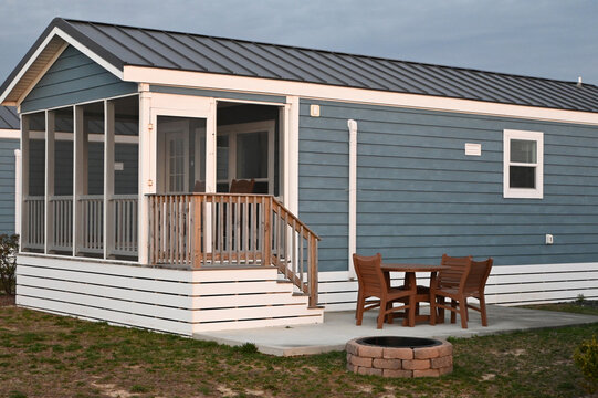 Blue single generic Modern camping cabin tiny home in a line on beach with screed in porch