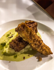 Crispy fried fish fillet with mashed potatoes and green sauce