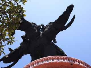 A breathtakingly majestic statue standing proudly against the clear blue sky above it