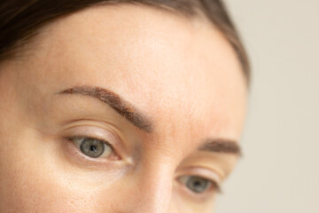 Female eyebrows after permanent makeup. Healing eyebrows. Closeup.