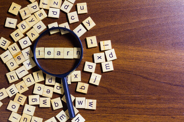 English letters scattered on wooden table surface. Idea to develop grammar thinking skills and...
