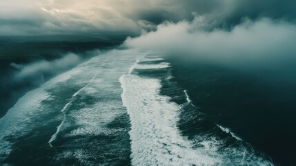 Dramatic oceanic vista: Majestic waves cascading under a sky of turbulent clouds