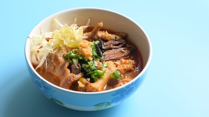 rice vermicelli with northern thai curry sauce on blue background