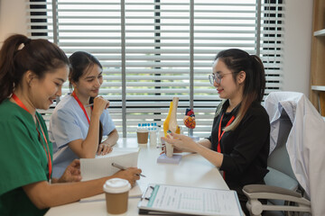 the three doctors are meeting to exchange new knowledge and information they have gained form their medical seminars with each other, a senior doctor is explaining information and knowledge