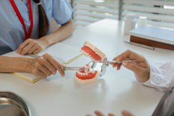the dentist is explaining to the assistant how she will treat a patient with wisdom teeth, the two dentists discussed the treatment plan for the patient with root canal treatment