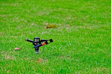 The sprinkler water automatic watering grass in garden.