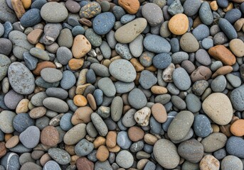 A close up view of many smooth rocks and pebbles in varying shades of gray and brown colors tone