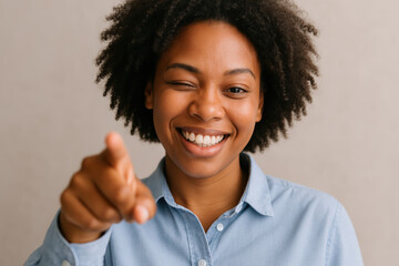 Smiling woman playfully winking and pointing at camera, showing friendly and confident attitude