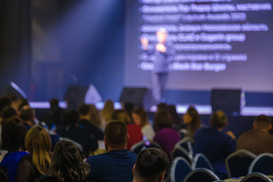 Focused audience members attentively listen to a keynote speech during a professional conference.