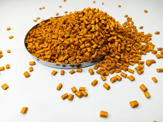 plastic masterbatch, masterbatch granules, polymer carrying pigment poured into a cup forming a...