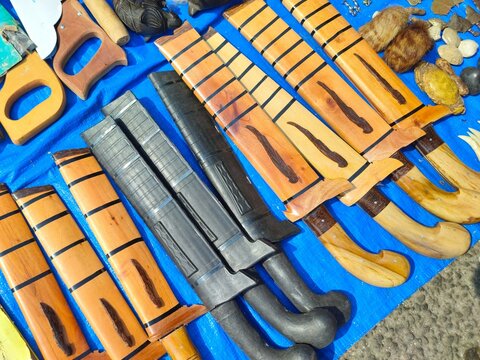 A row of machetes, traditional weapons from Indonesia on a blue background