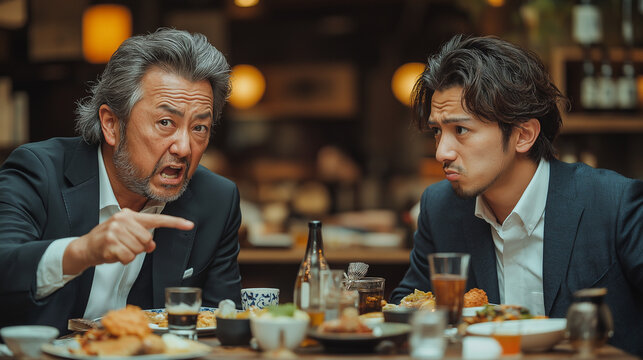 居酒屋で上司に説教されるビジネスマン