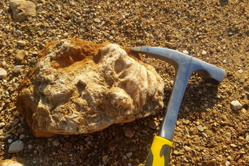 A trek for minerals, a geological tool at the side of a discovered rock