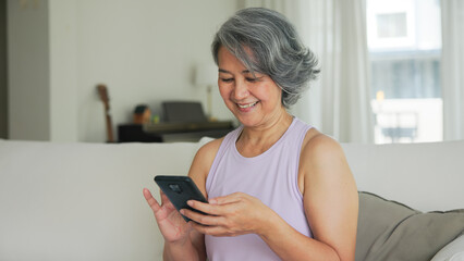 Asia adult people middle age happy relax old woman using mobile ask AI chatGPT chat bot look health...