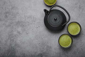 Traditional japanese matcha tea ceremony set on grey stone background, including a black iron...