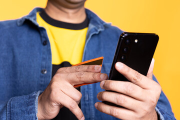 Smiling happy customer typing credit card digits online on webpage to process the payment and confirm the purchase with the bank. Upbeat jolly indian guy buying things on sale.