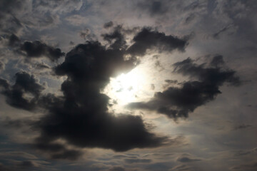 A dark cloud in the sky blocks the light of the sun