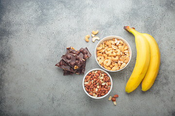 Assortment of food rich in a magnesium: cashews, peanuts, bananas, and chocolate hazelnuts, a...