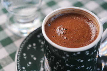 Enjoying turkish coffee in a cozy cafe setting with checkered tablecloth