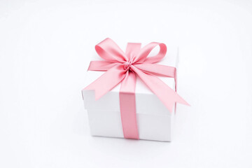 Obraz premium white gift box with a pink ribbon tied around it