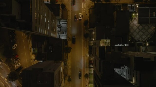 Top-down drone view of illuminated night traffic and high-rise buildings in Miraflores, Lima, Peru