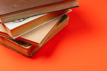 Vintage books on a vibrant orange background showcasing timeless tales