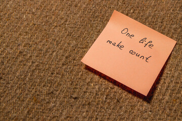 Motivational sticky note with inspiring message on textured surface