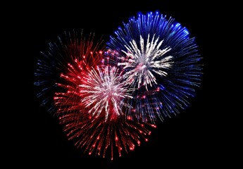 Fototapeta premium Colorful fireworks display with red, white, and blue bursts lighting up the night sky in a celebratory scene.