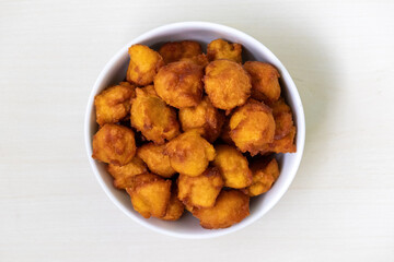 Top view of traditional Bengali cakes or pastries, known locally as taler pitha or taler bora, made with the pulp of the tal palm fruit, presented in a white bowl.