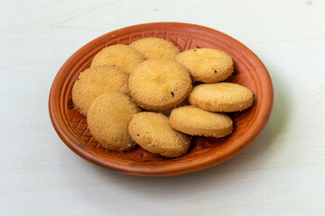 Delicious, salty cookies biscuits on a clay plate, set against a wooden background. Their buttery goodness will leave you craving more.