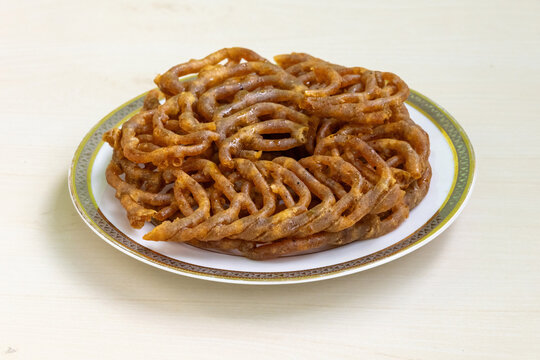 Delicious Shahi jilapi or jalebi on a white ceramic plate. Shahi jilapi, a famous traditional sweetmeat originating from Chowk Bazaar in Old Dhaka, Bangladesh, is very popular in the country.