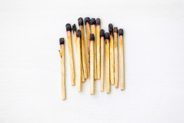 Burnt match sticks isolated on a white background. Many burnt wooden matchsticks in a row.