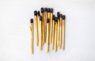 Burnt match sticks isolated on a white background. Many burnt wooden matchsticks in a row. Top view.