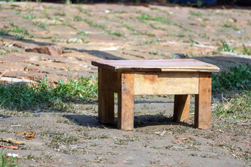 A wooden bench placed outdoors on grassy garden ground, perfect for rustic design projects, environmental campaigns, or minimalist artistic compositions.