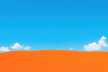 Fototapeta premium Vivid orange sand dune meets vibrant blue sky. Soft clouds dot the azure expanse