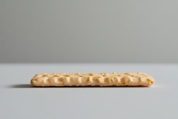 An isolated rectangular biscuit displayed on a smooth surface