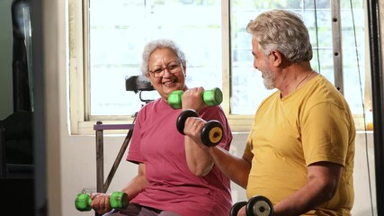 Active indian senior couple doing exercises in gym, Healthy asian elderly people weight lifting training with dumbbells at health club, Vitality and retirement life, Fitness india. 4k - Powered by Adobe