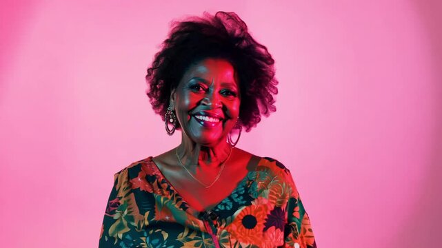 Ambient light pan video to capture a senior woman fashion model in a quirky outfit featuring bold patterns, vibrant pink background