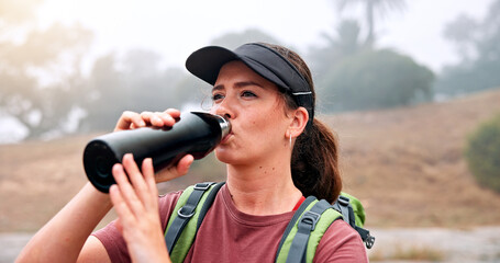 Break, drinking water and hiking with woman outdoor in nature for adventure, hobby or journey. Bottle, hydration and vacation with thirsty hiker person in park for morning exploration or health