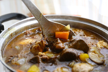 preparing a Japanese style currywith fresh meat, vegetables and curry roux; home cooking