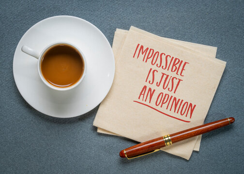 Impossible is just an opinion - inspirational writing on a napkin with coffee